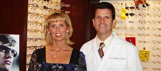 Tim and Kelly Bellevue, owners of Falmouth Vision Center, in front of the frame display